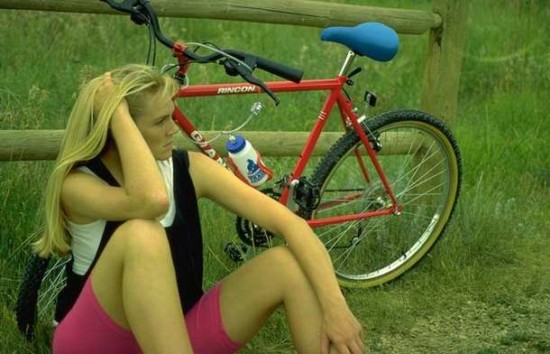 Mujer apoyada en una verja descansando